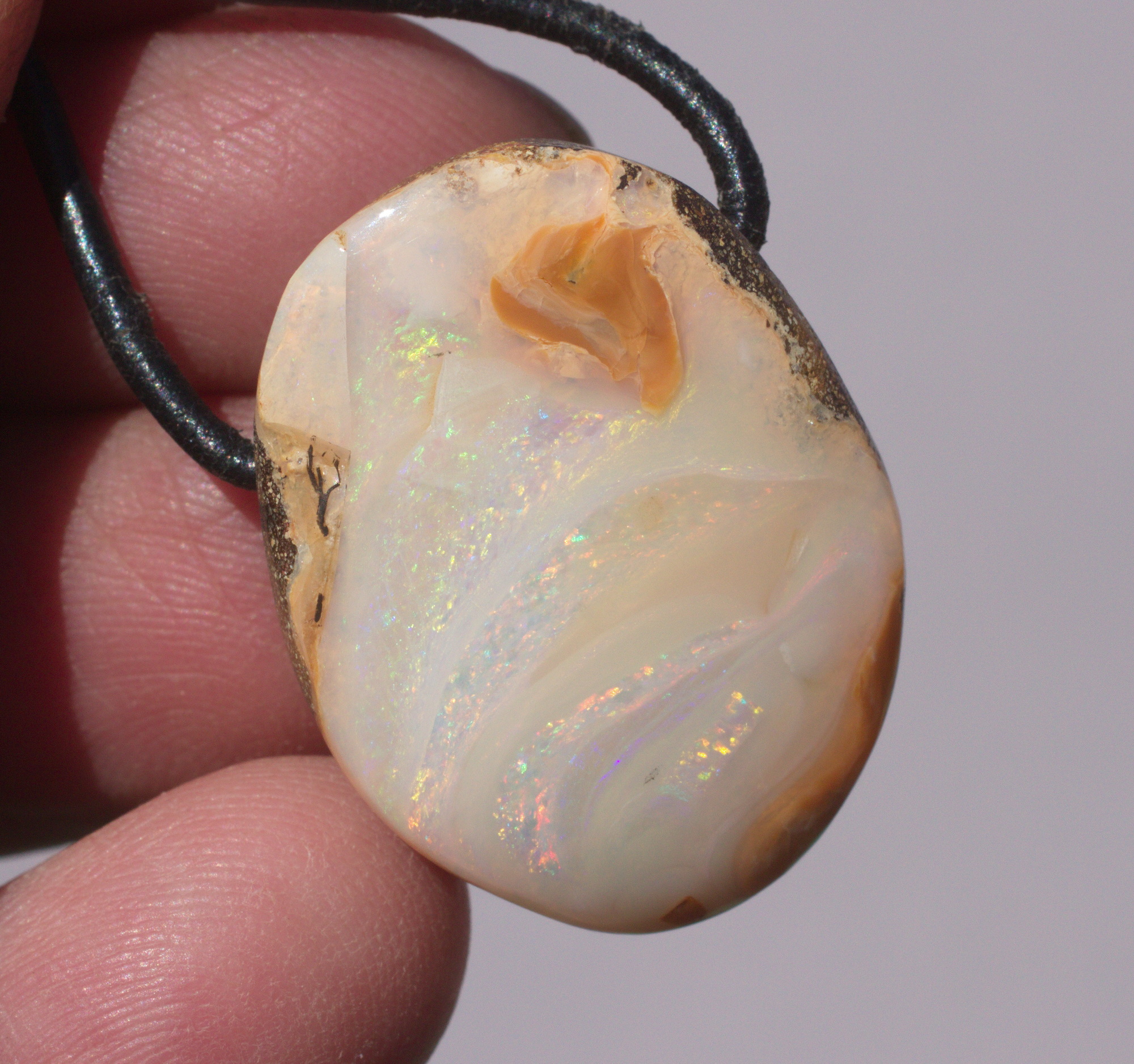 Bernsteinfarbener Boulderopal, seitlich gebohrt mit Lederband  