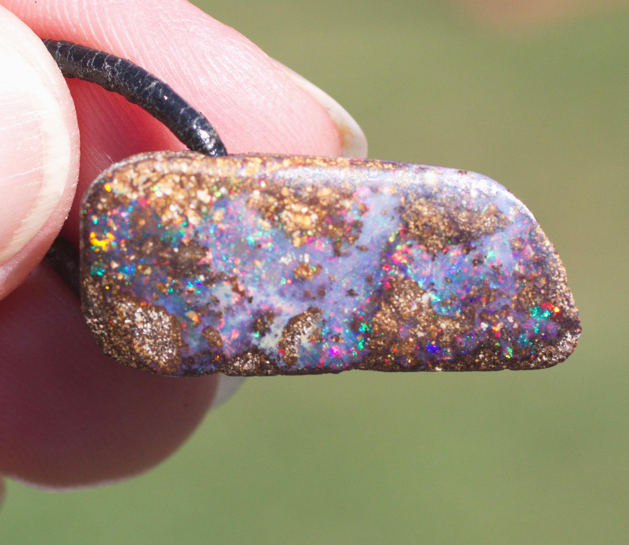 Bräunlicher Boulderopal mit vielen Farben, seitlich gebohrt mit Lederband Bräunlicher Boulderopal mit vielen Farben, seitlich gebohrt mit Lederband