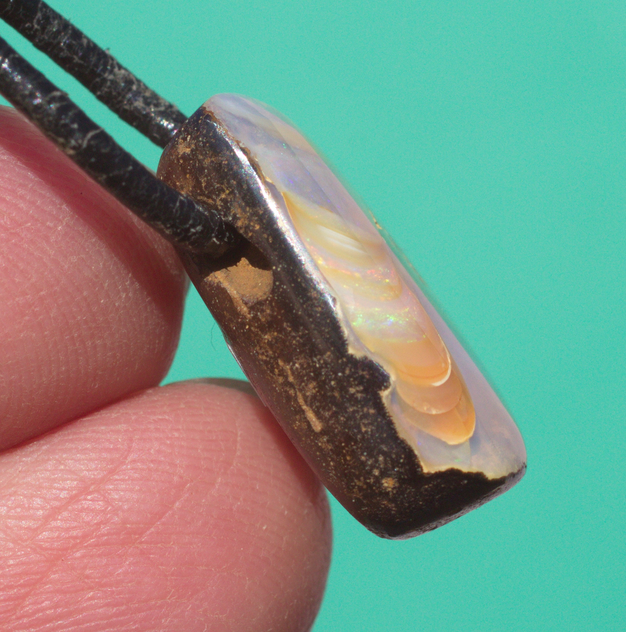 Bernsteinfarbener  Boulderopal, seitlich gebohrt mit Lederband  