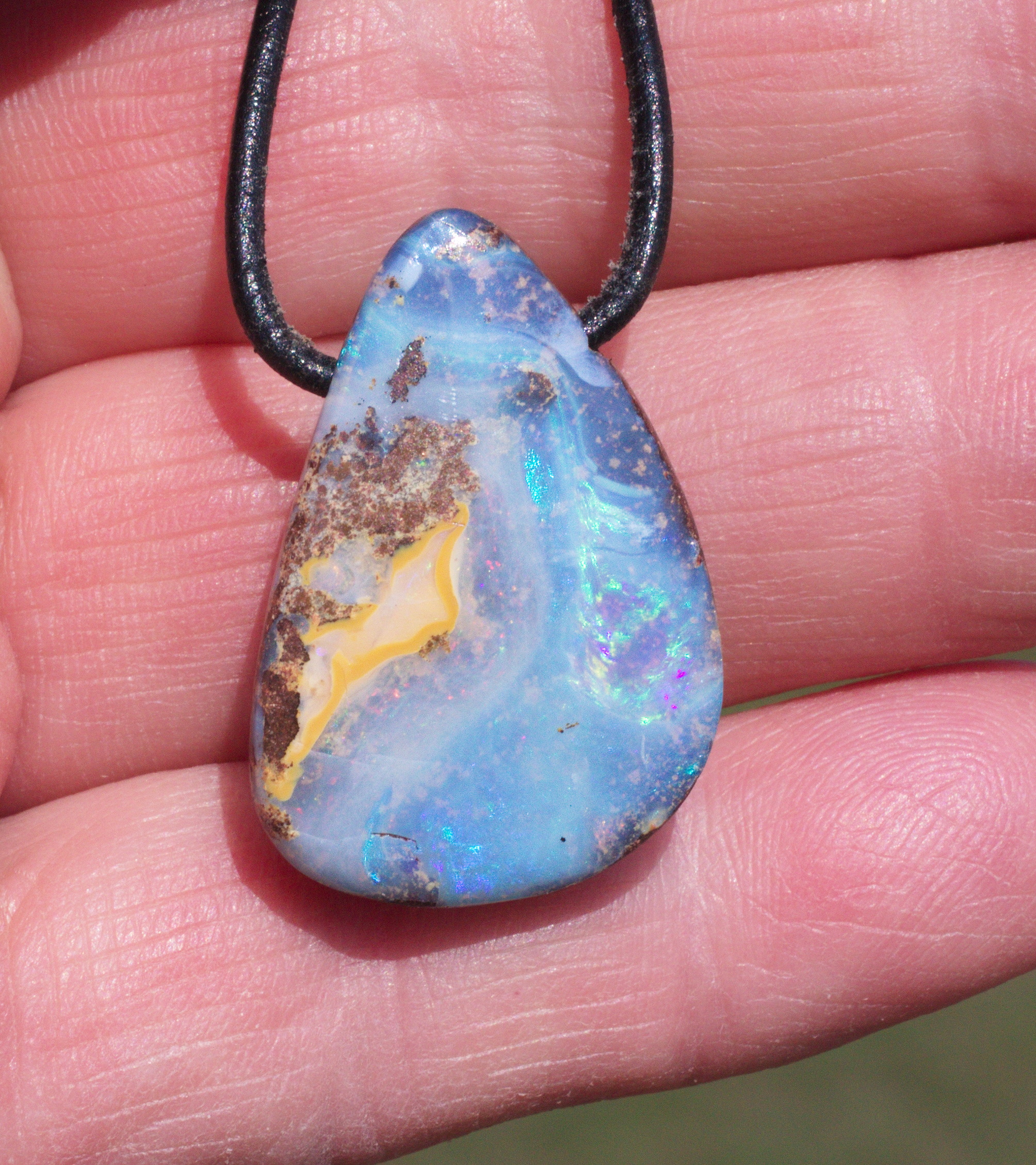 Hellblauer Boulderopal, seitlich gebohrt mit Lederband  