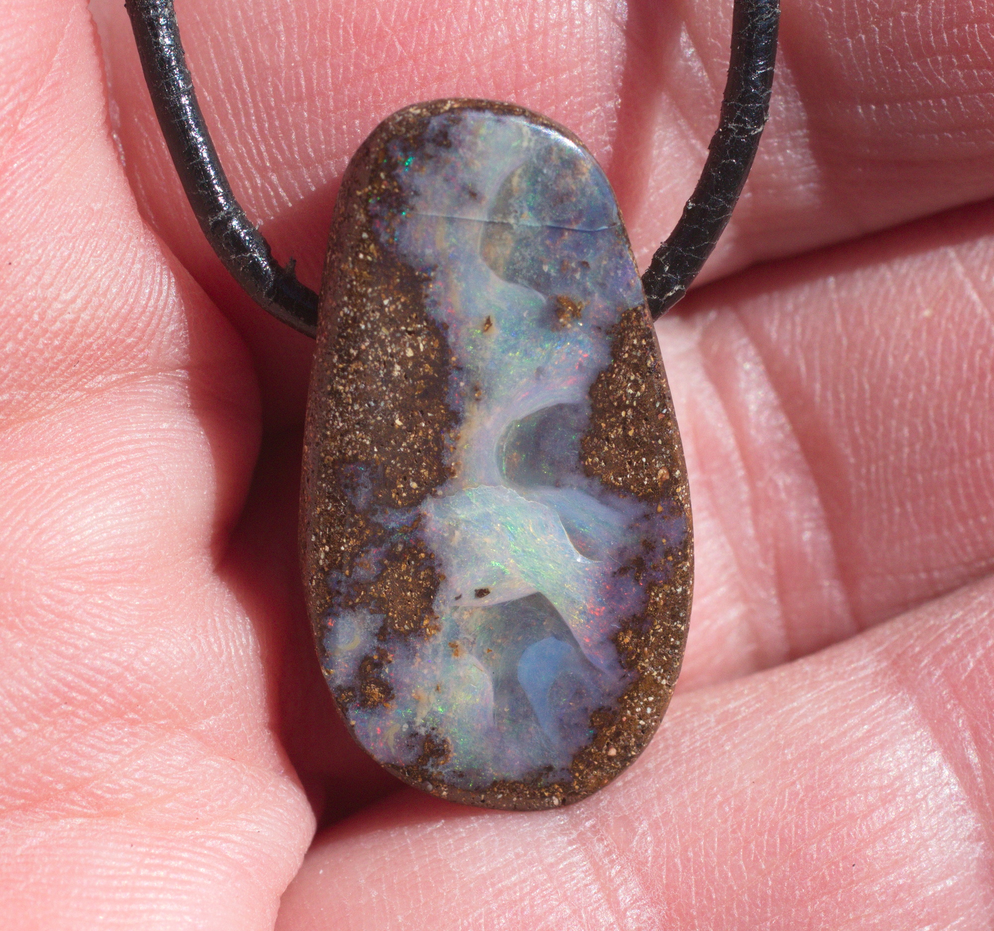 Ovaler Boulderopal, seitlich gebohrt mit Lederband 
