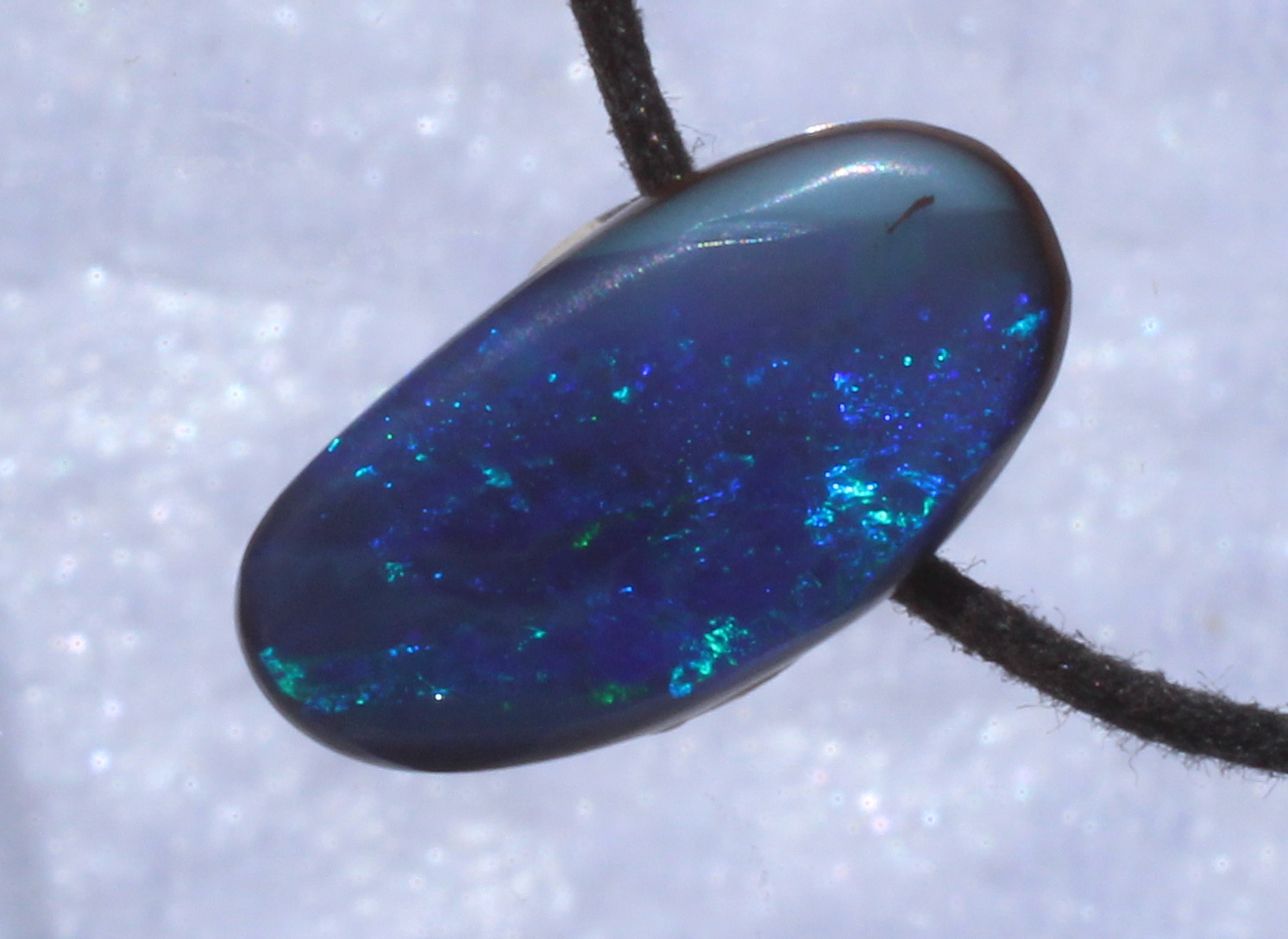Blauer Boulderopal, seitlich gebohrt mit Lederband 