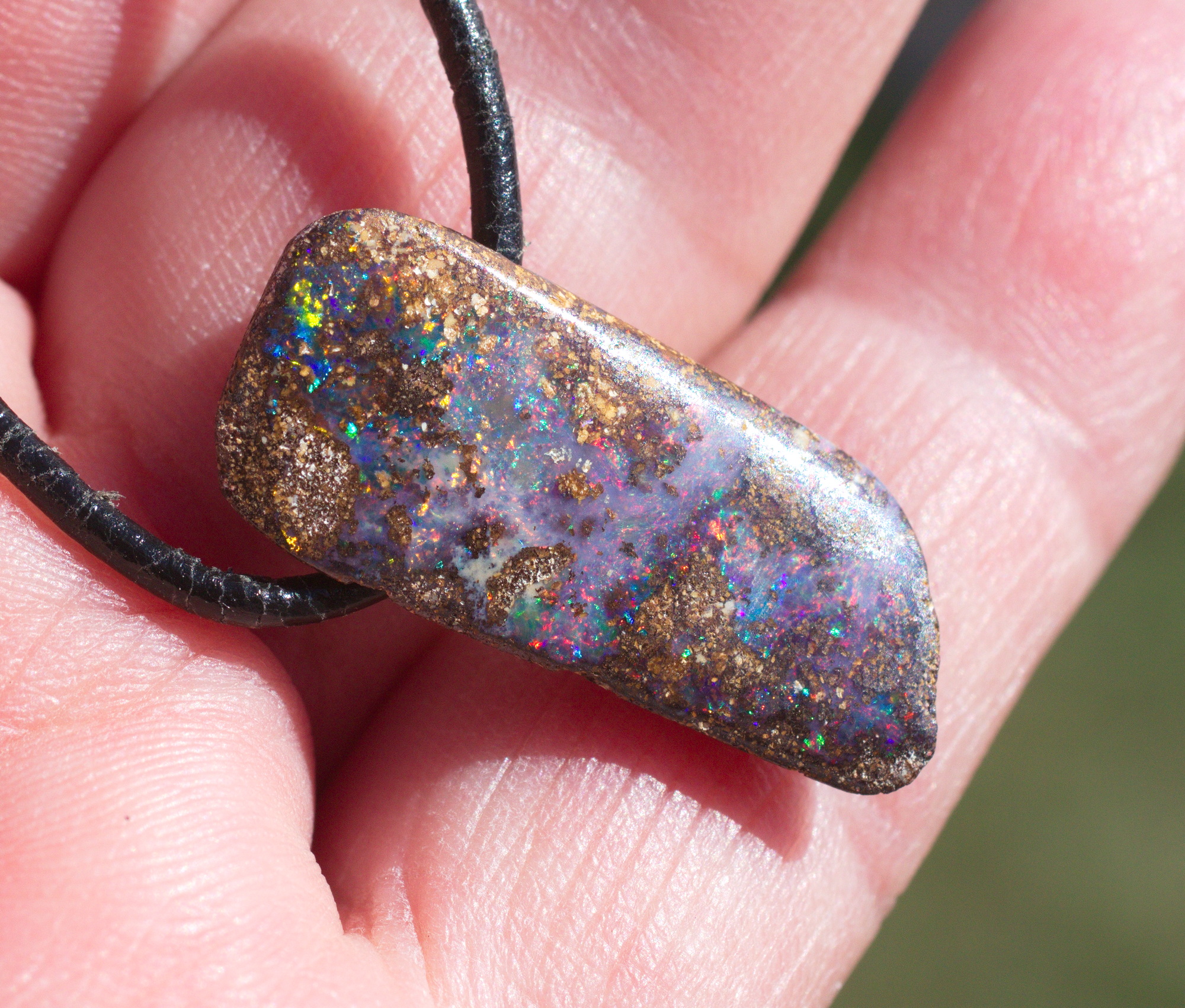 Bräunlicher Boulderopal mit vielen Farben, seitlich gebohrt mit Lederband Bräunlicher Boulderopal mit vielen Farben, seitlich gebohrt mit Lederband