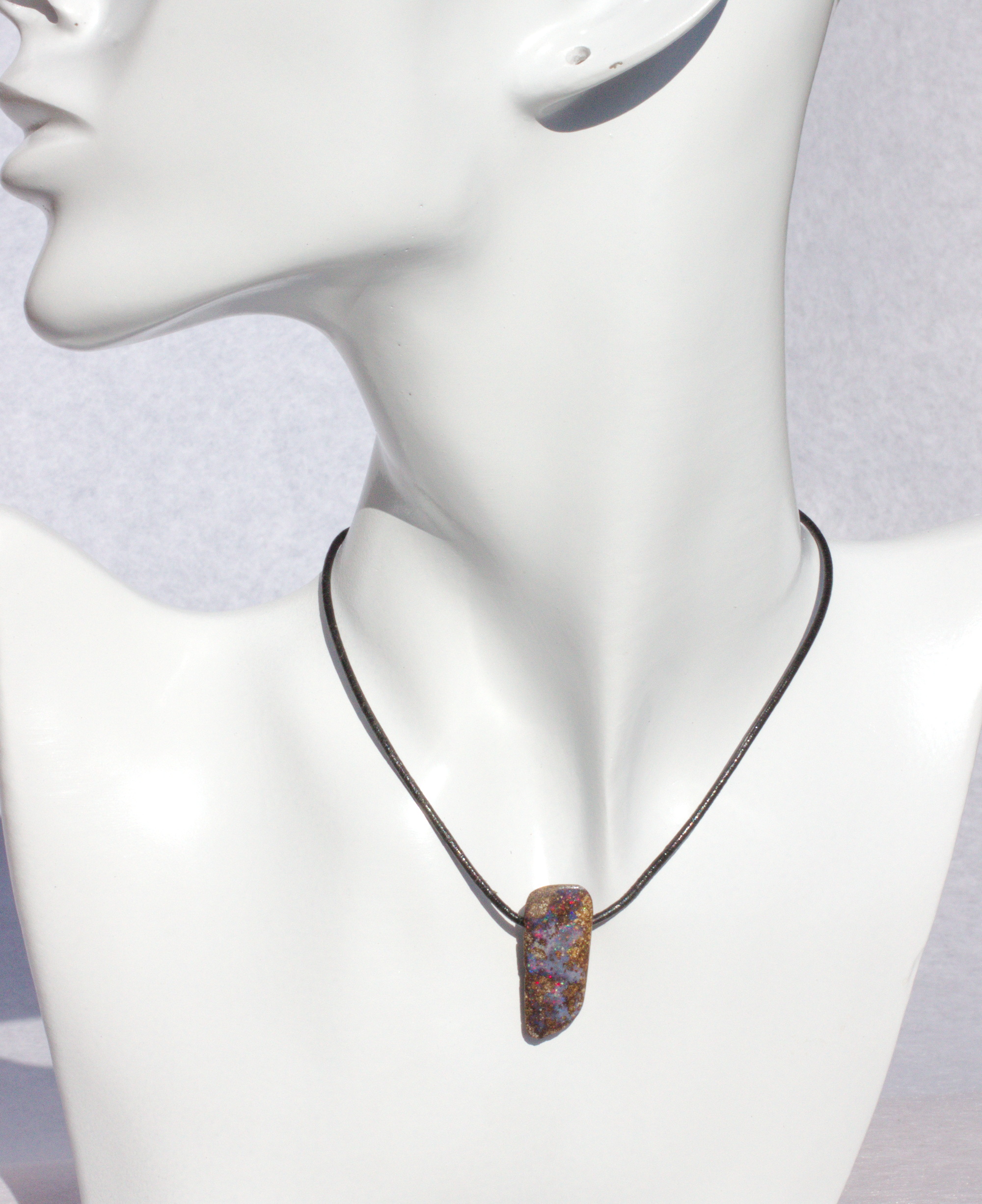 Bräunlicher Boulderopal mit vielen Farben, seitlich gebohrt mit Lederband Bräunlicher Boulderopal mit vielen Farben, seitlich gebohrt mit Lederband