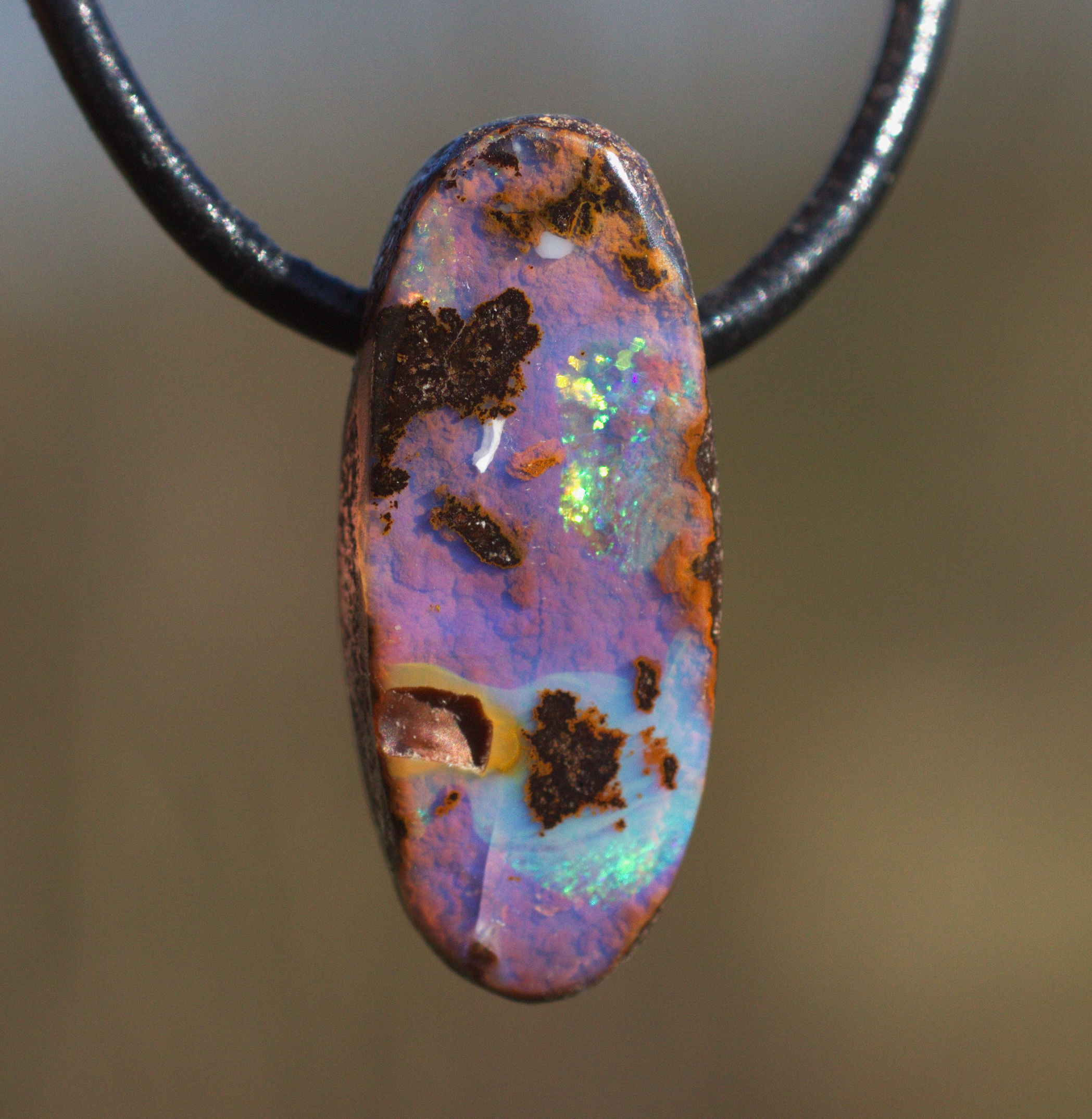 Kleiner ovaler Boulderopal, seitlich gebohrt mit Lederband 