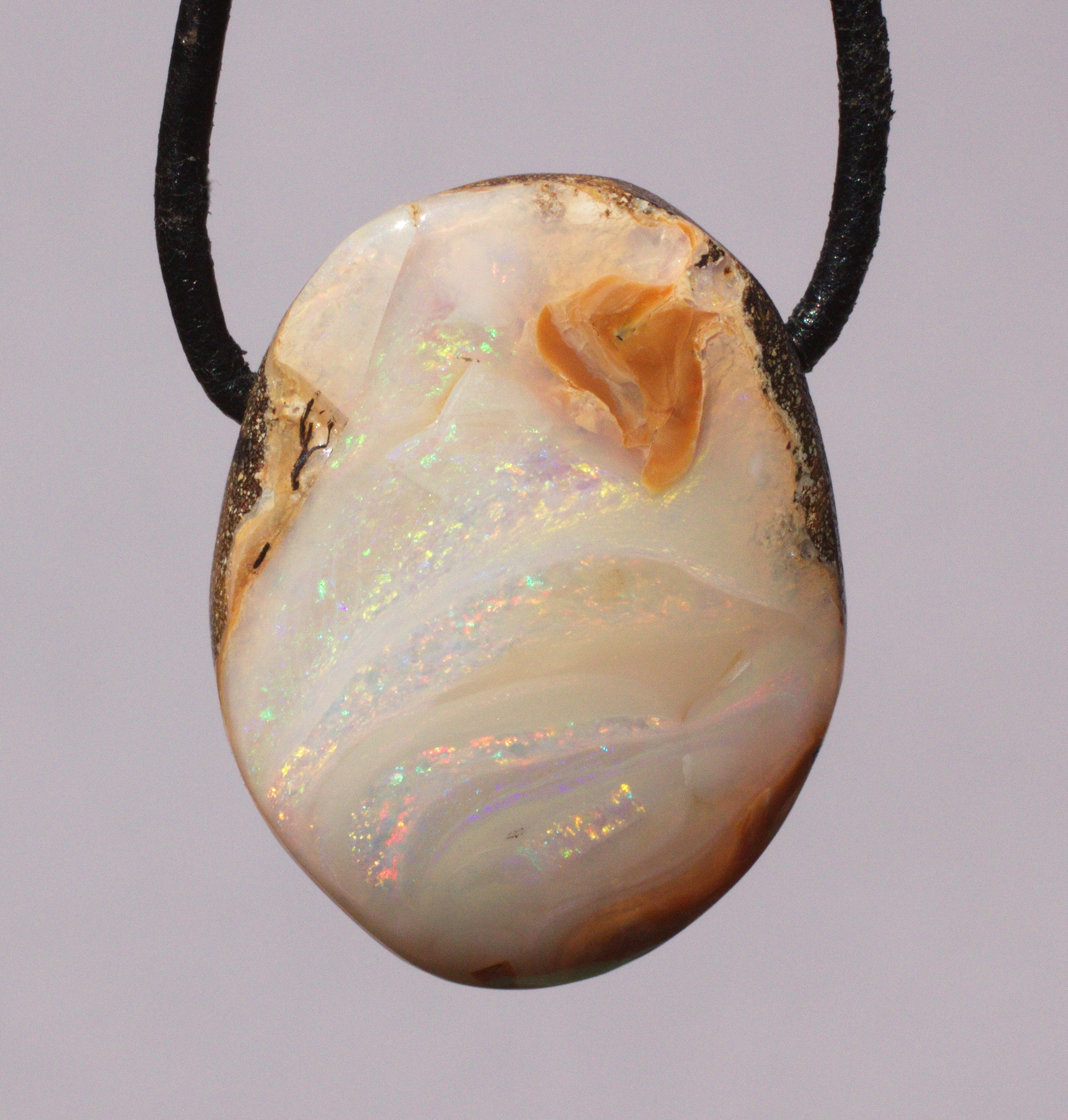 Bernsteinfarbener Boulderopal, seitlich gebohrt mit Lederband  