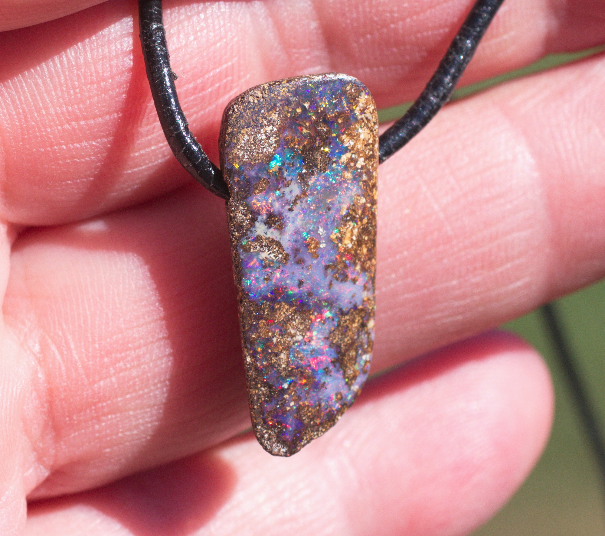 Bräunlicher Boulderopal mit vielen Farben, seitlich gebohrt mit Lederband Bräunlicher Boulderopal mit vielen Farben, seitlich gebohrt mit Lederband