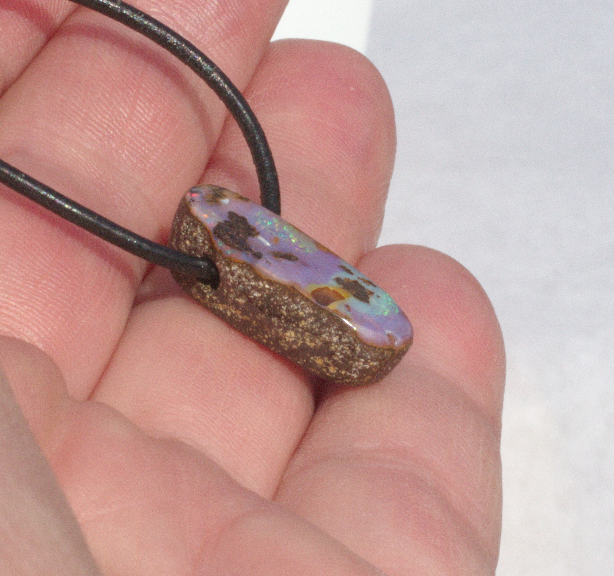 Kleiner ovaler Boulderopal, seitlich gebohrt mit Lederband 