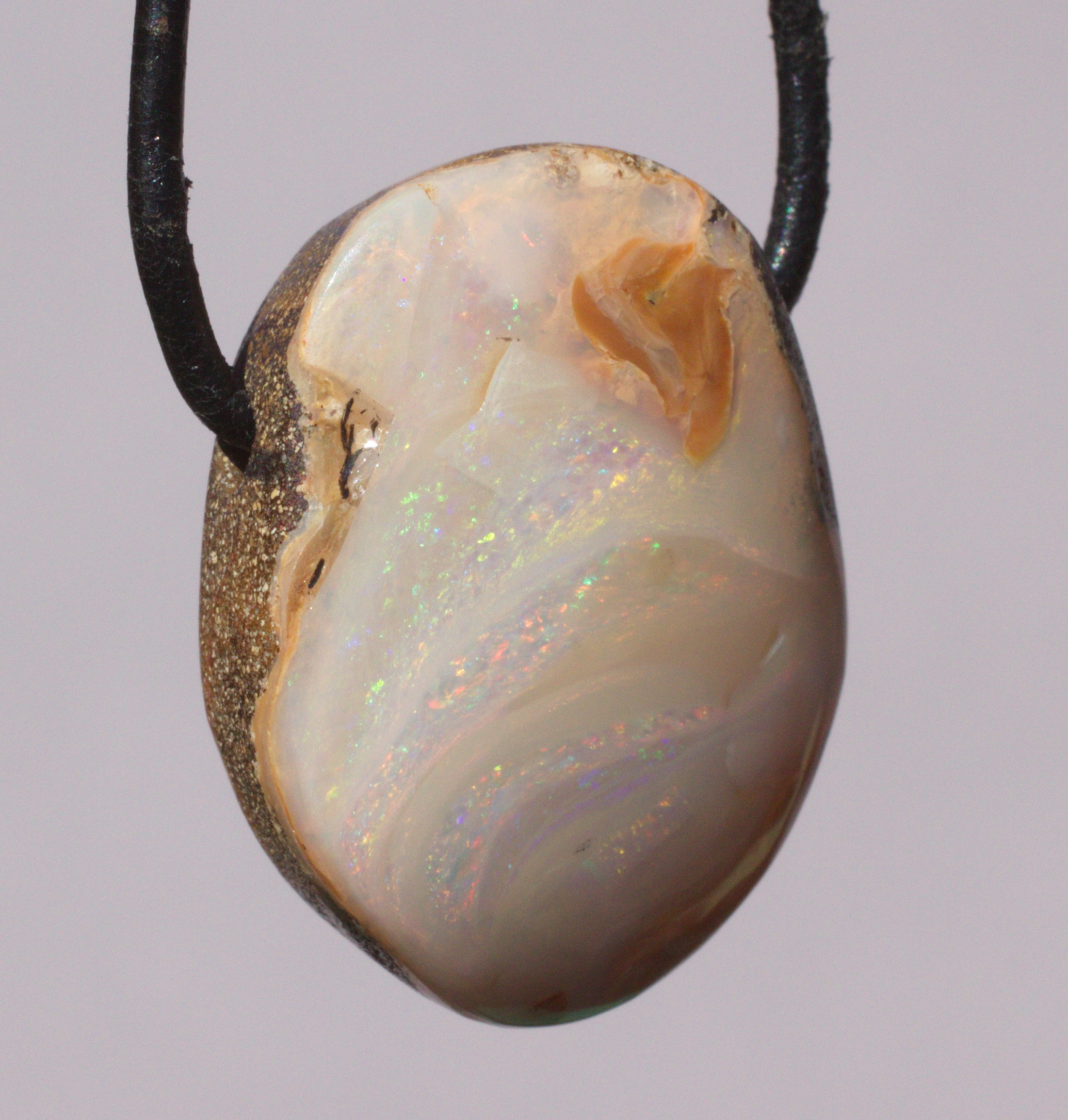 Bernsteinfarbener Boulderopal, seitlich gebohrt mit Lederband  