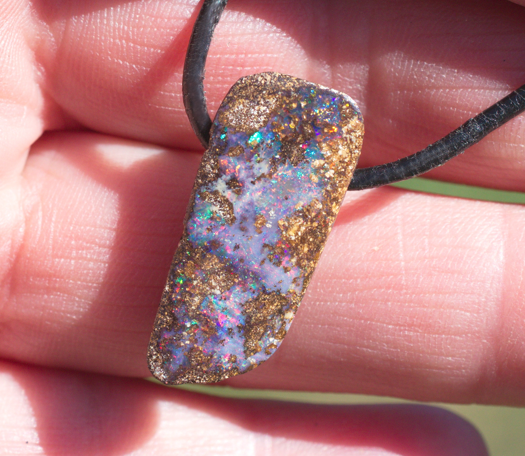 Bräunlicher Boulderopal mit vielen Farben, seitlich gebohrt mit Lederband Bräunlicher Boulderopal mit vielen Farben, seitlich gebohrt mit Lederband