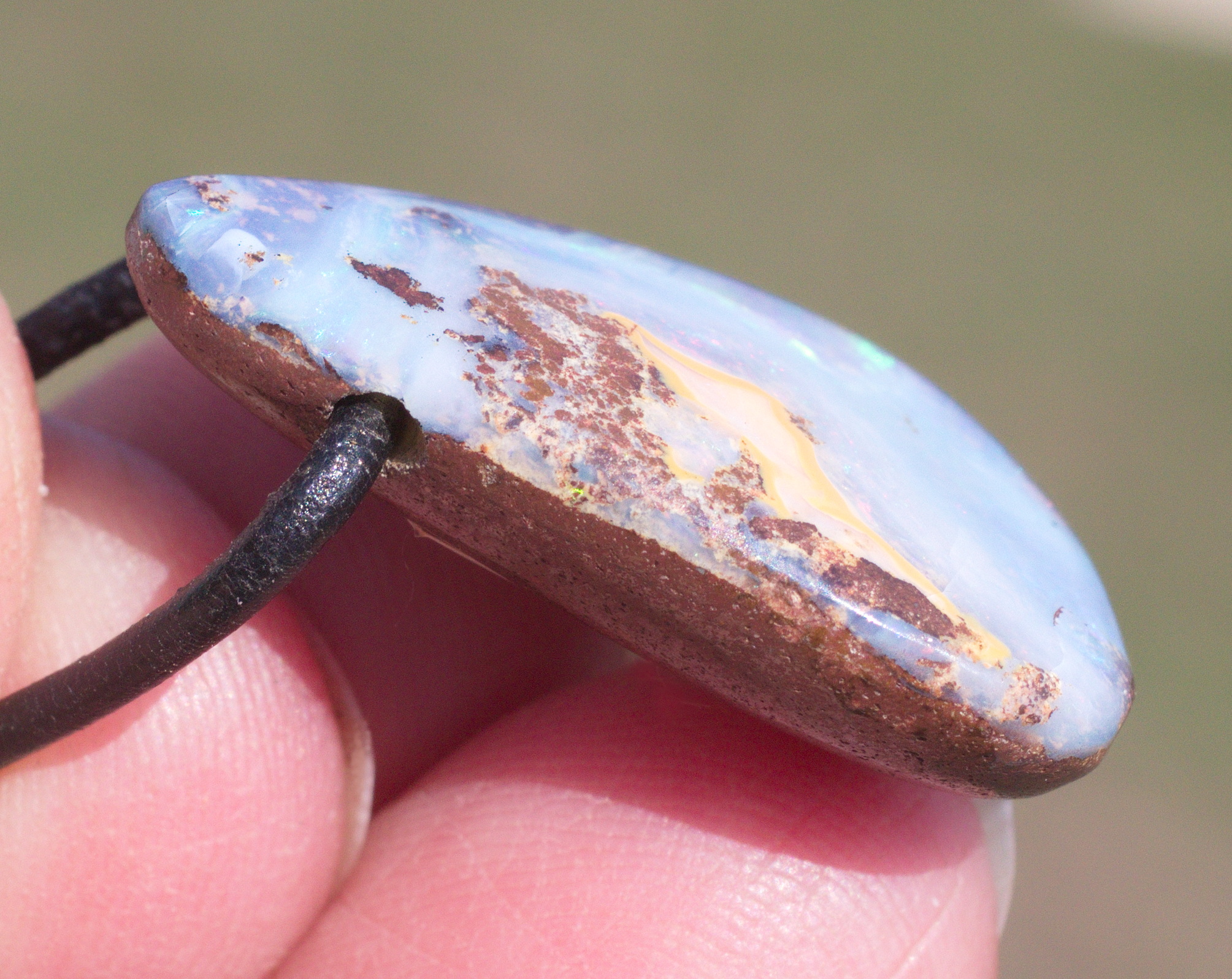 Hellblauer Boulderopal, seitlich gebohrt mit Lederband  
